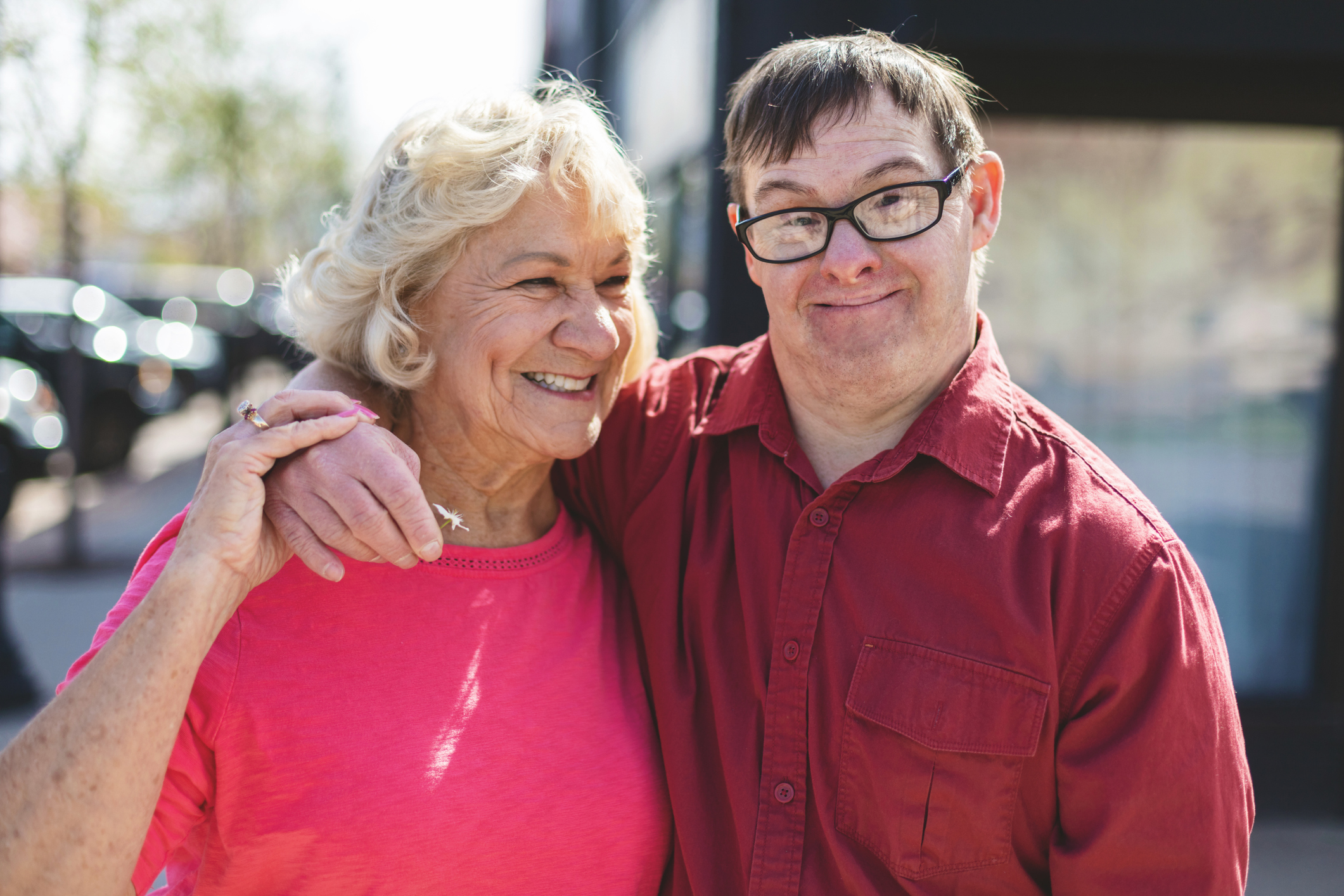 Adult Man with Down Syndrome Outdoors with Senior Female Guardian